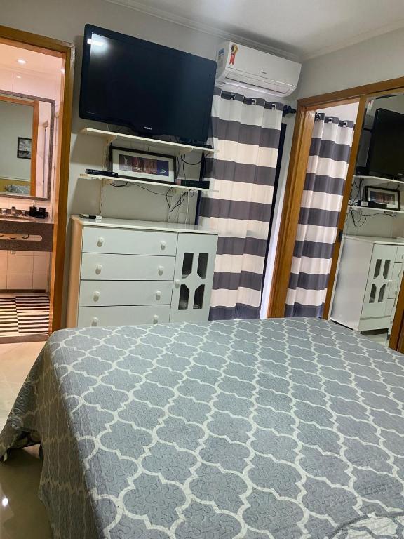 ein Schlafzimmer mit Bett und Flachbildfernseher in der Unterkunft LP House in Bicas