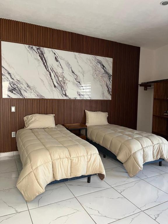two beds sitting next to each other in a bedroom at Valle Stay in Cedro