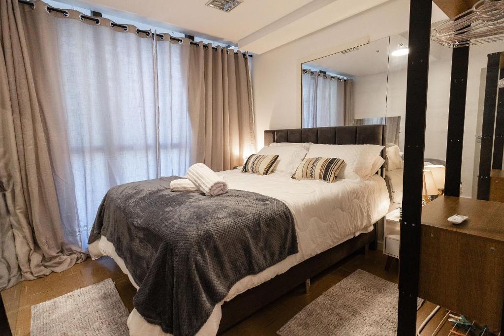 a bedroom with a large bed and a mirror at P&G Apto 203-Bagnoregio in Caxias do Sul