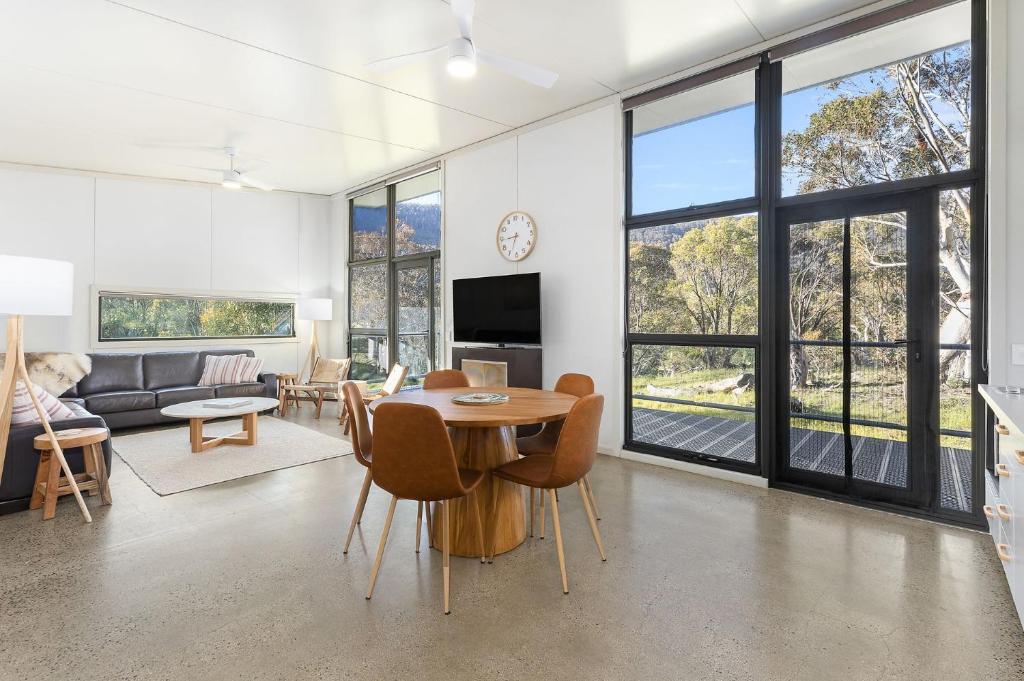 a living room with a table and a couch at Ecocrackenback Luxe Chalet 5 in Crackenback