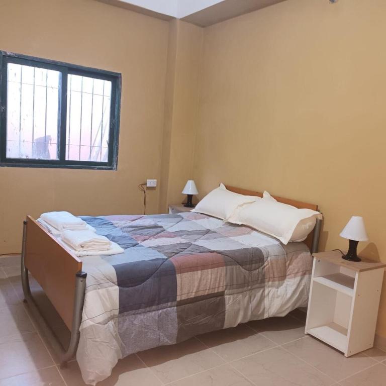 a bedroom with a large bed and a window at Departamento Cómodo y Accesible in Humahuaca