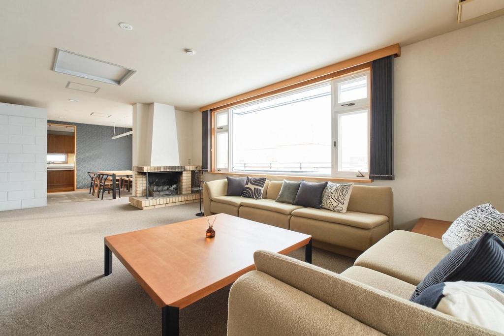 a living room with two couches and a table at villa Jin Asahikawa in Asahikawa