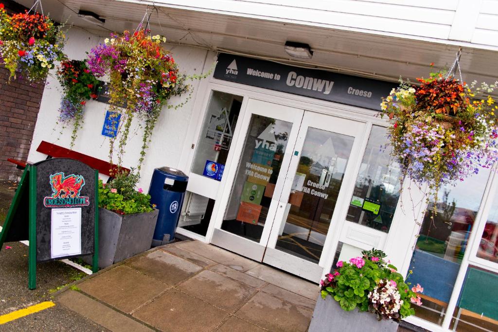 un magasin de comté avec des fleurs devant lui dans l'établissement YHA Conwy, à Conwy