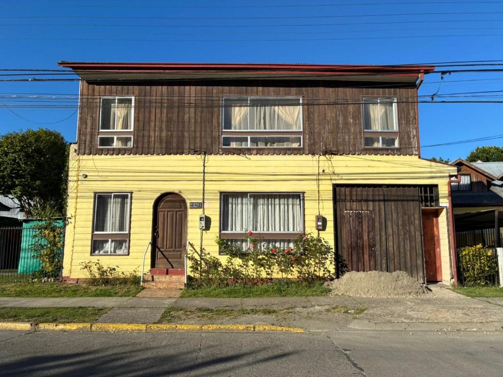 an old yellow house with a brown at Bercy in Valdivia