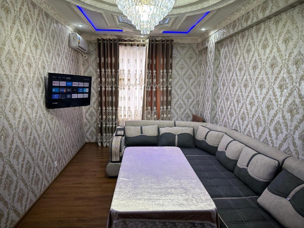 a conference room with a couch and a tv at Karimbek Guest house by SamApart in Samarkand