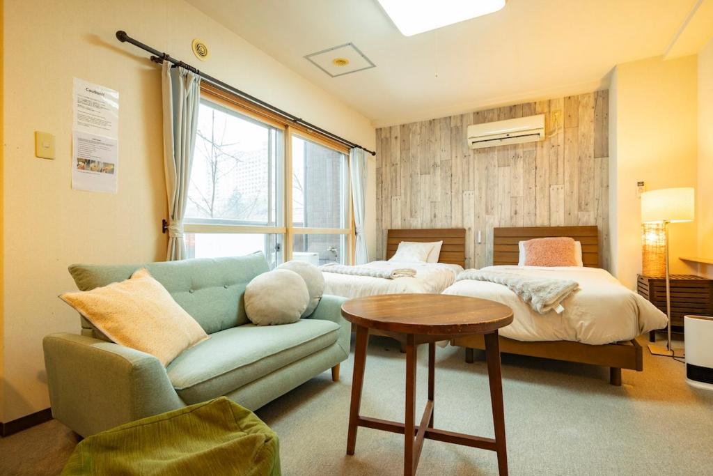 a living room with a couch and a bed at Fewdays Condominium108 in Sapporo