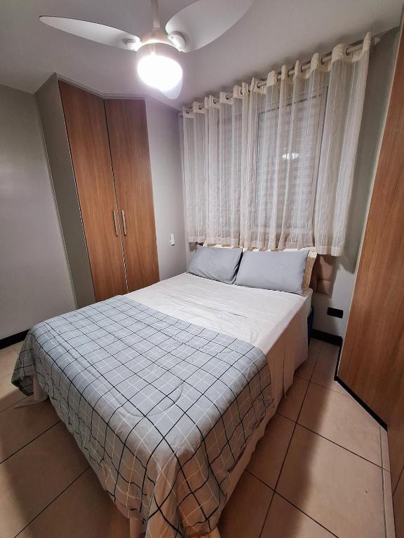 a bedroom with a bed and a large window at Apto 3 dorms proximo a UFABC e CPTM in Santo André