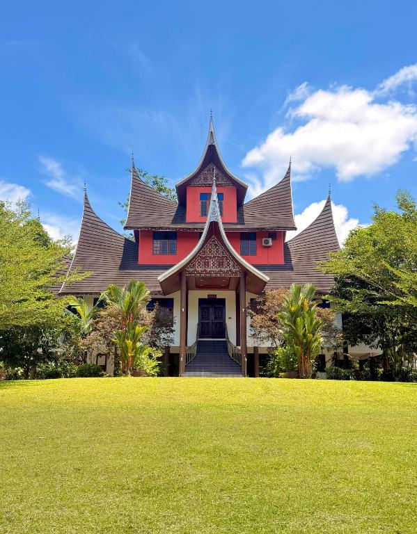 a large house with a green lawn in front of it at Astana Az-Zahrah in Bahau