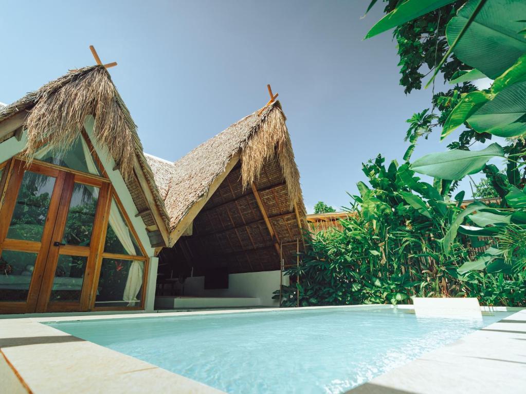 a villa with a swimming pool and a resort at Vibes Villas Siargao in General Luna
