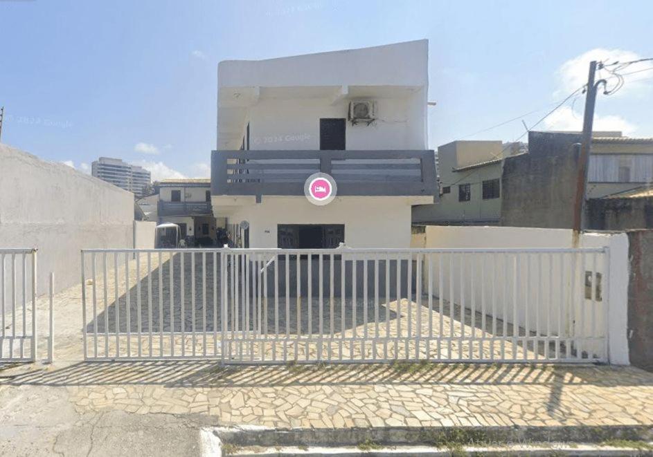 a white fence in front of a building at Quarto na Atalaia in Aracaju