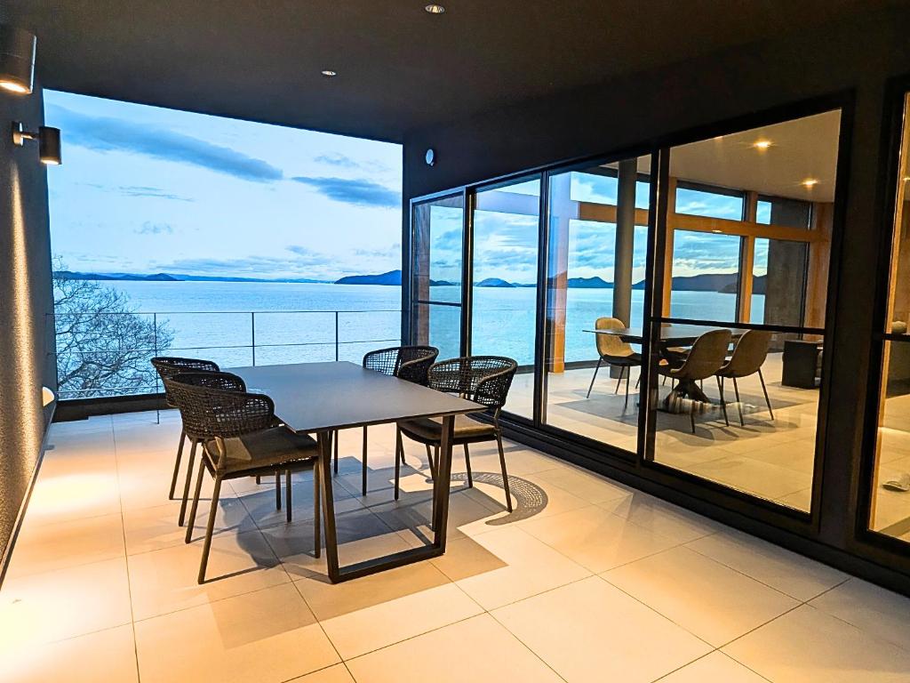 a dining room with a table and chairs on a balcony at Villa CASK Setouchi in Mitoyo