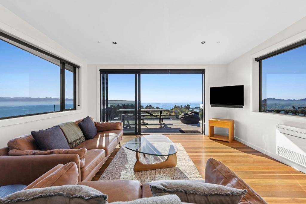 a living room with leather furniture and large windows at Vista al Mar in Pohara