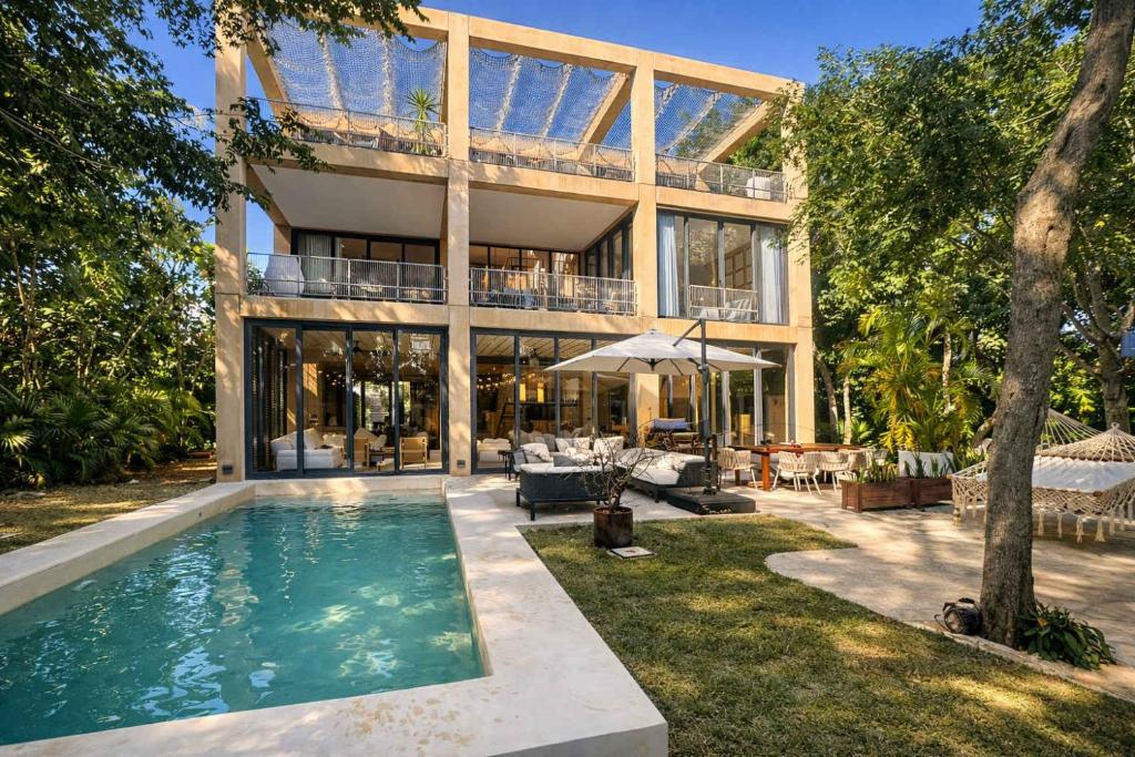 a house with a swimming pool in front of it at Luxury Villa in Corasol 4BR Private Pool in Playa del Carmen