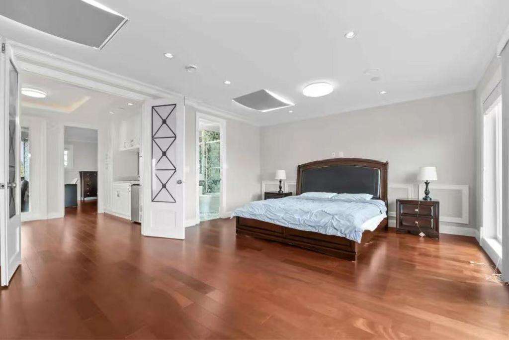 a large bedroom with a bed and a wooden floor at 嘉博旅馆 Jiabo Hotel in Richmond