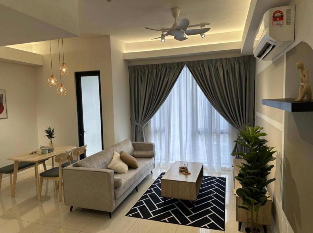 a living room with a couch and a table at seroja hills condominium in Sepang