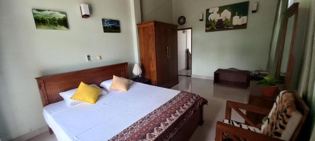 a bedroom with a bed with two yellow pillows at Villa 86 in Pamunugama