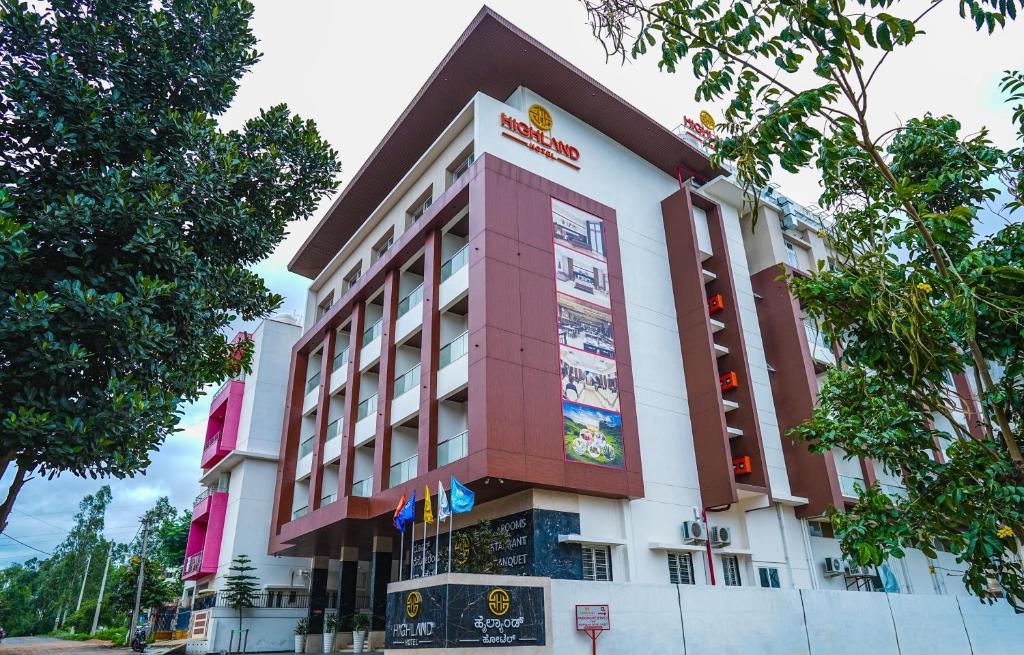 a building with a sign on the side of it at Highland Hotel in Bangalore