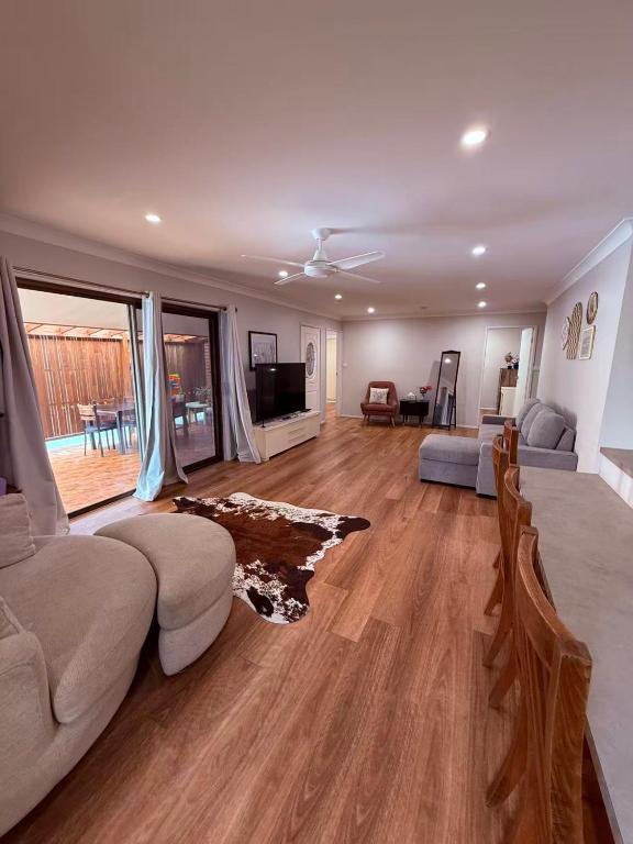 a living room with a couch and a tv at Charming Riverside Retreat sleep6 in Dora Creek