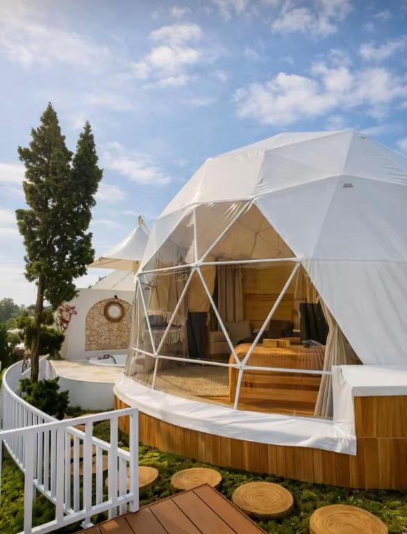 a large white tent with a wooden deck at Naima 1 in Bandung
