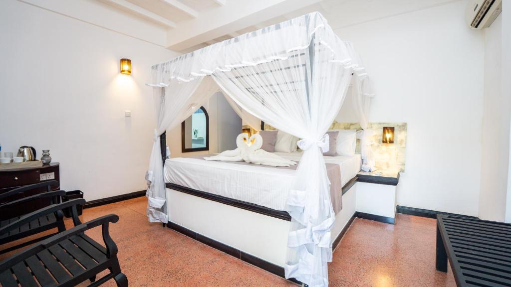 a bedroom with a bed with a canopy at La Roche Hotel Sigiriya in Sigiriya