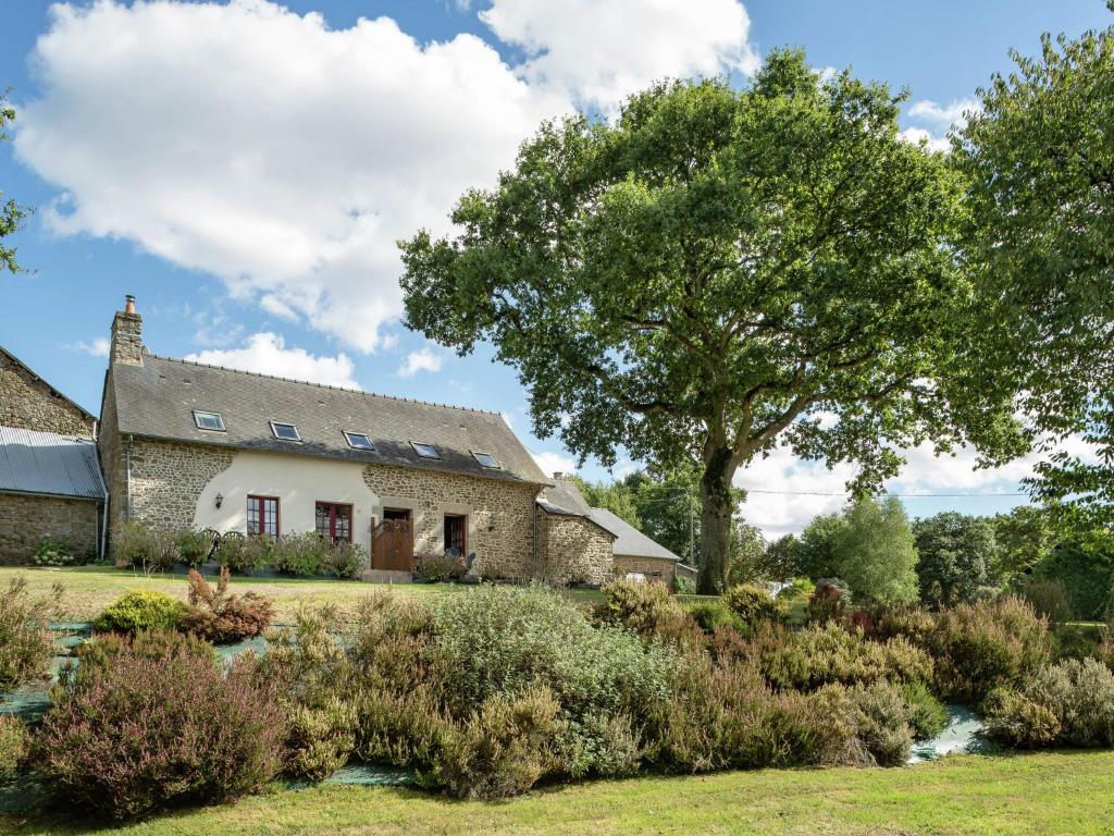 een oud stenen huis met een boom en een tuin bij Charming Holiday Home in Bonnemain overlooking a Pond in Bonnemain