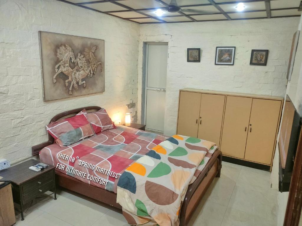 a bedroom with a bed and a painting on the wall at Ivory Room, AC, Smart TV, Ensuite, Independent Homestay in Mumbai