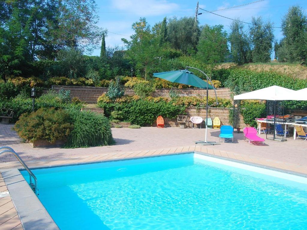 una piscina con sombrilla, mesa y sillas en Belvilla by OYO Massarella Due, en Fucecchio