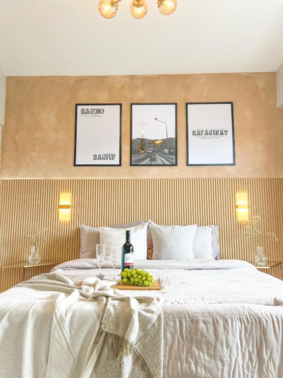 a bed with a tray of grapes and a bottle of wine at Mi Casa de Baguio by North Sierra in Baguio