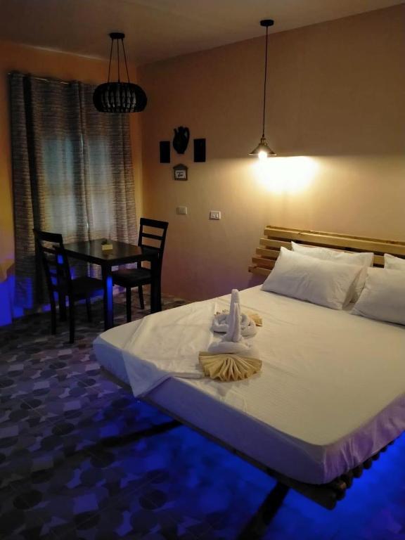a bedroom with a large bed and a table with chairs at Datoni Italian Restaurant in Tabigue