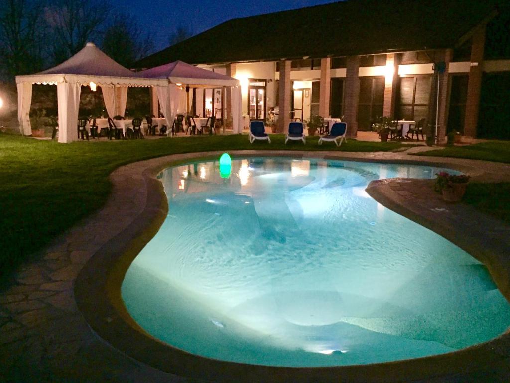 a large swimming pool in a yard at night at Motel Cosmera in Savigliano
