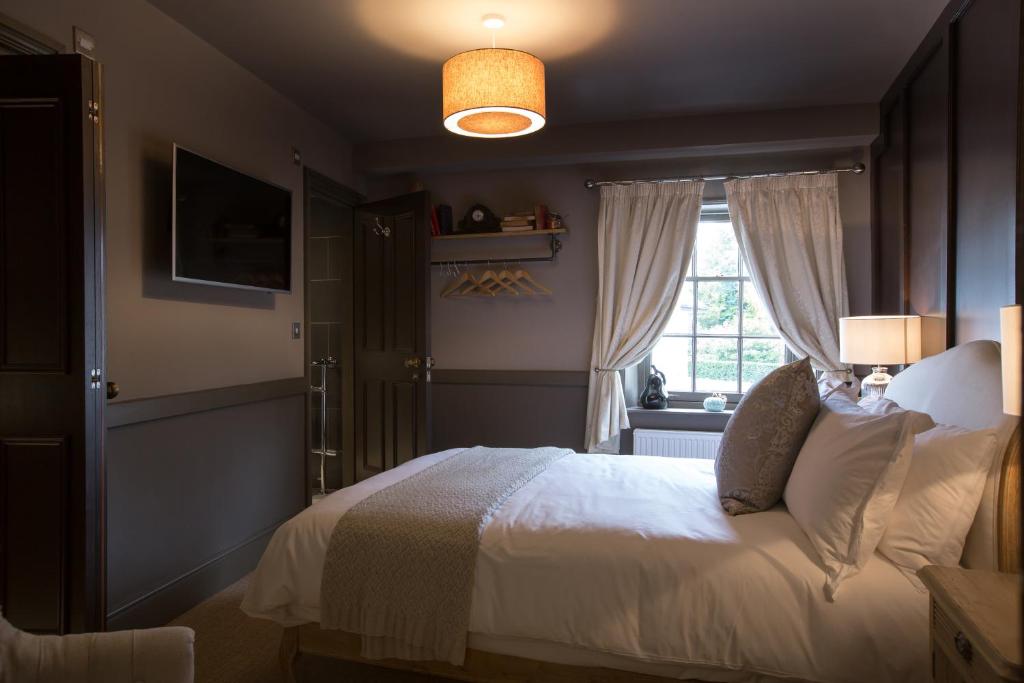 a bedroom with a white bed and a window at The Minster Arms in Wimborne Minster
