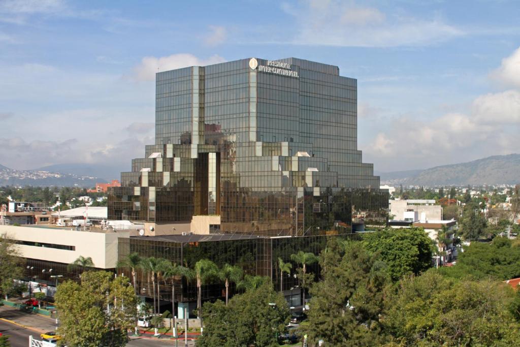 a large glass office building in a city at Presidente InterContinental Guadalajara by IHG in Guadalajara