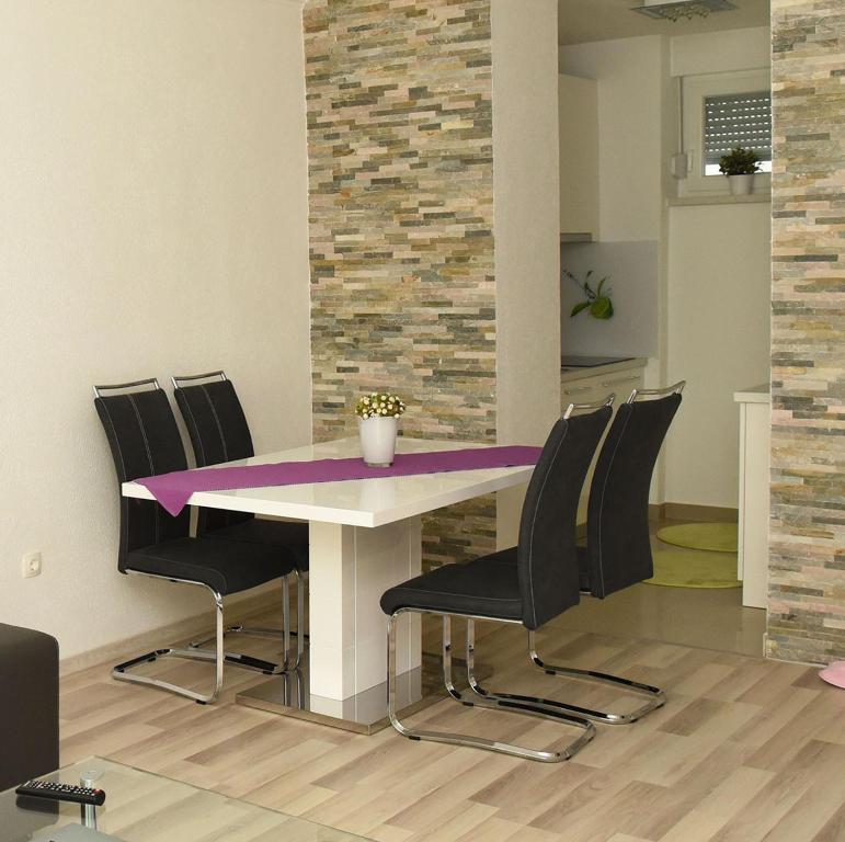 una sala da pranzo con tavolo e sedie viola di Angelina Apartment a Zaprešić