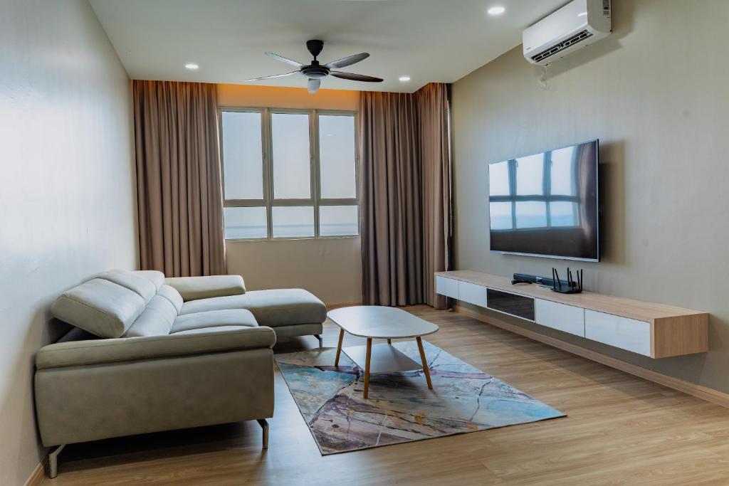 a living room with a couch and a flat screen tv at KT Seaview City Suite in Kuala Terengganu