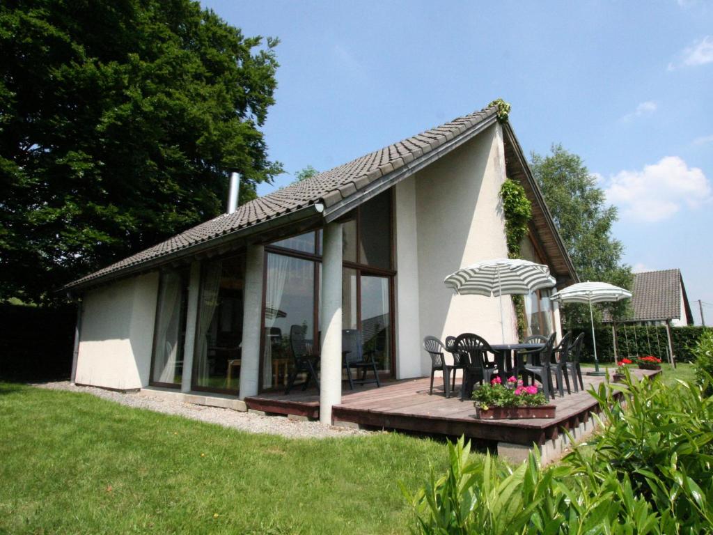 Ce petit cottage blanc dispose d'une terrasse et de chaises. dans l'établissement this cottage is a superb chalet, à Malmedy