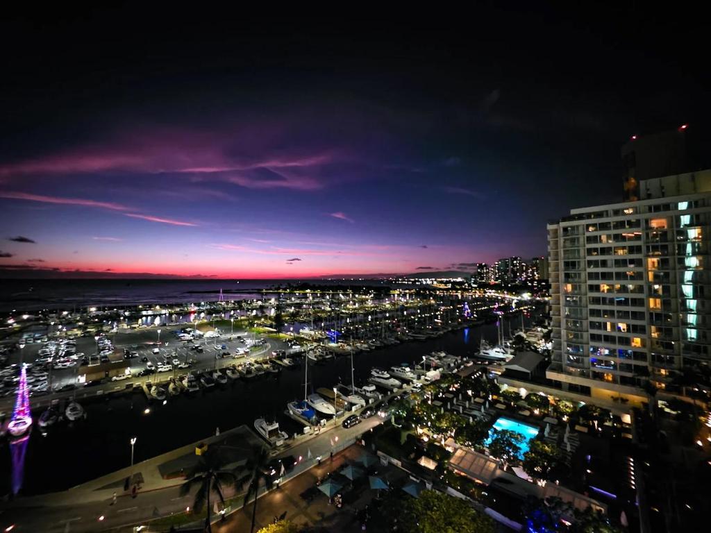 a view of a city at night with a harbor at Ilikai Hotel Condo with Kitchen and Ocean View in Honolulu