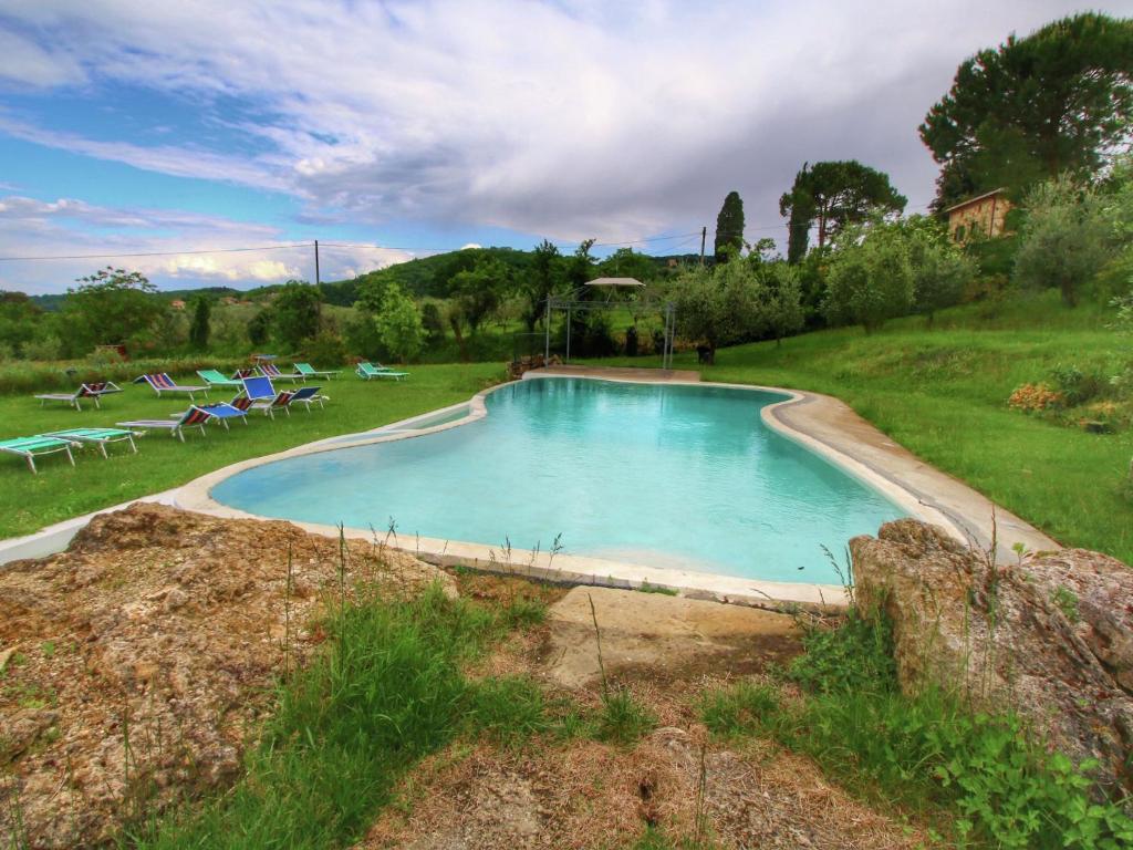 a large swimming pool in a grassy field at Belvilla by OYO Villa Valardegna in Montepulciano