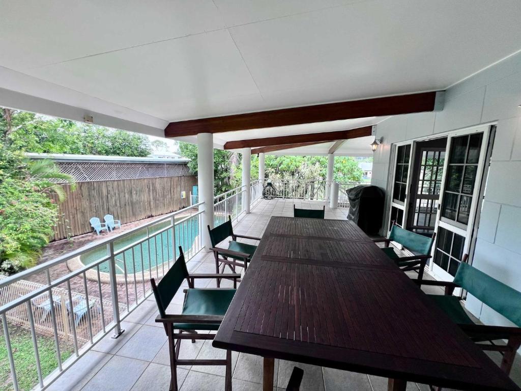 a deck with a wooden table and chairs on a balcony at Flying Fish House in South Mission Beach