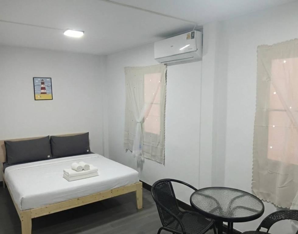 a bedroom with a bed and a table and chairs at Middle Road Hostel in Nathon Bay