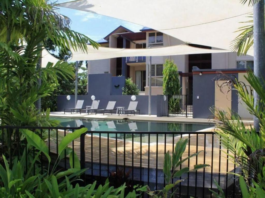 a house with a swimming pool with lounge chairs at BHA 4 Beachfront Bliss 2 bed in Mission Beach