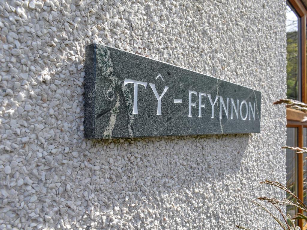 a sign on the side of a building at Ty Fynnon Cottage-Uk2786 in Penmaen-mawr