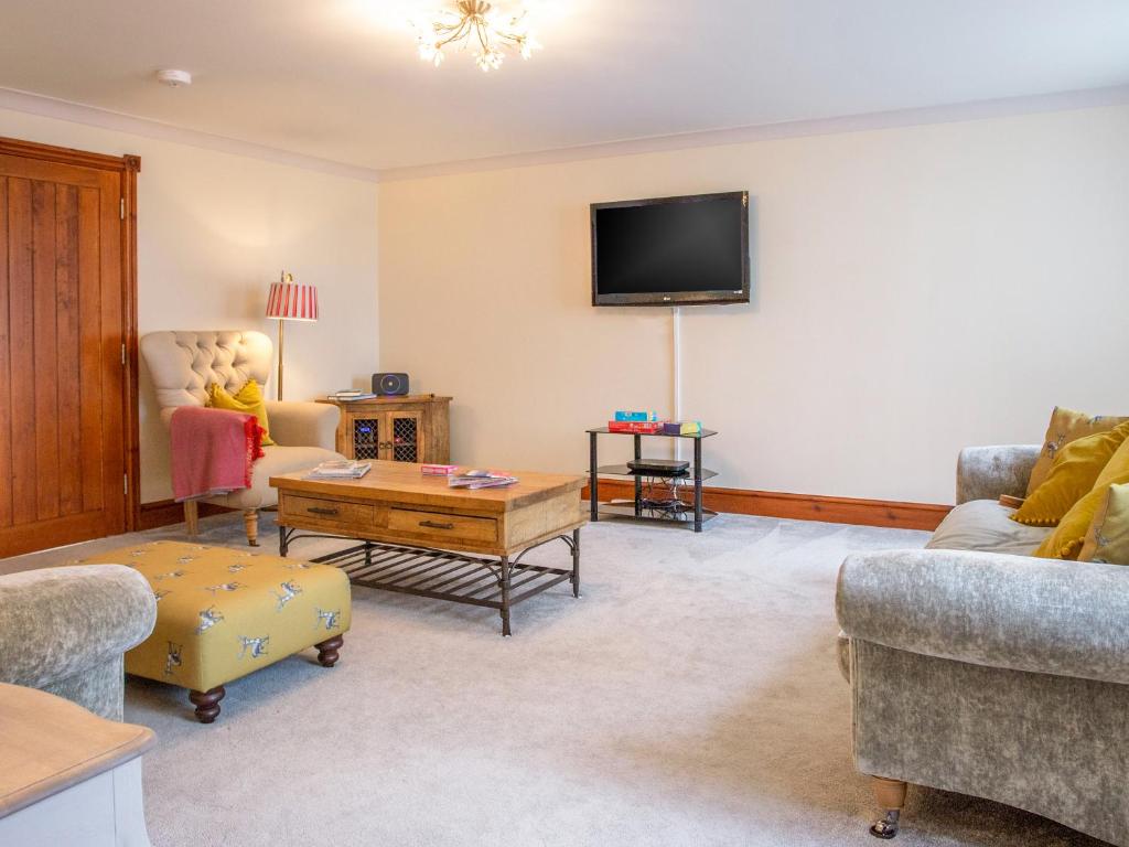 a living room with two couches and a flat screen tv at Willow Cottage-Uk2788 in Penmaen-mawr