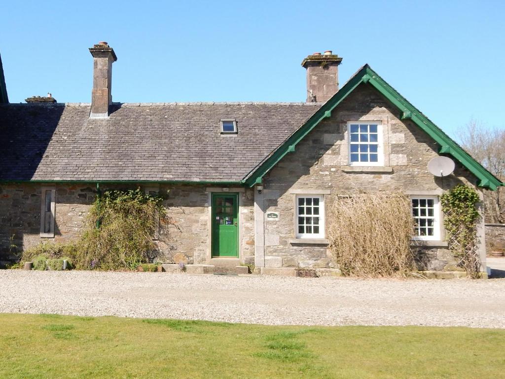 an old stone house with a green door at The Stable - 31240 in Kilmartin