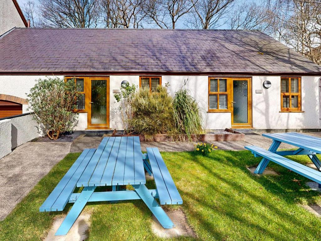 a blue picnic table in front of a house at Elm Cottage-Uk2791 in Penmaen-mawr