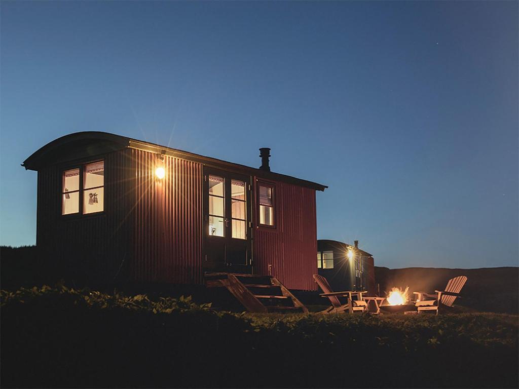 a cabin with a fire in front of it at night at Lapwing Shepherds Hut - Uk7631 in Pitlochry
