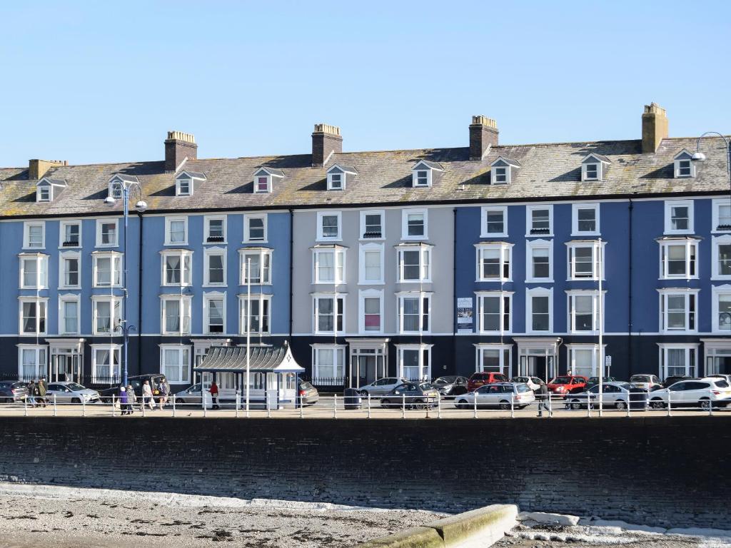 a large blue building with cars parked in front of it at Seaside Apartment-Uk2801 in Aberystwyth