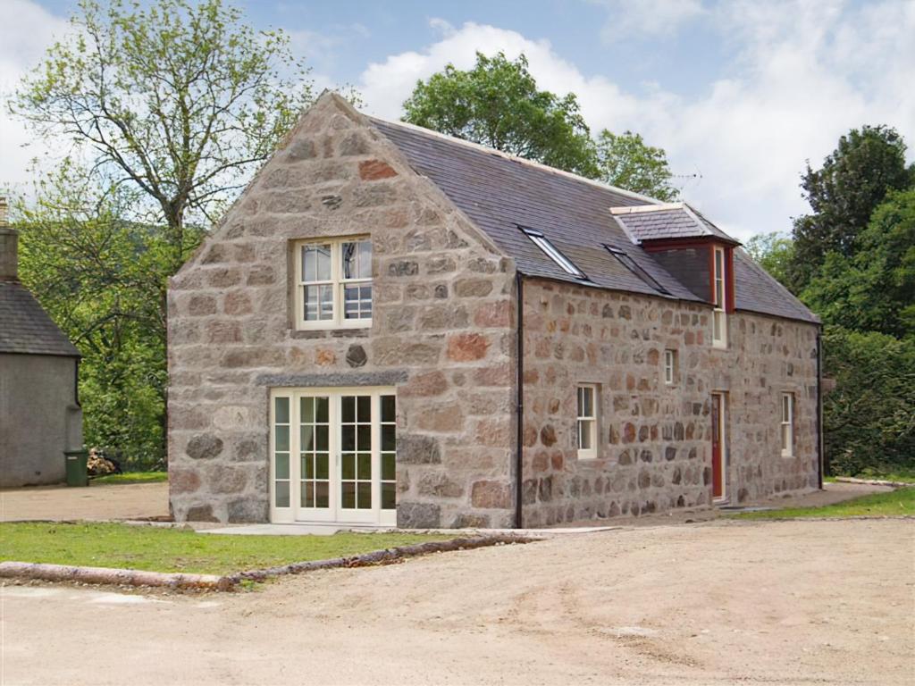 an old stone building with a white door and windows at Greenlands in Banchory
