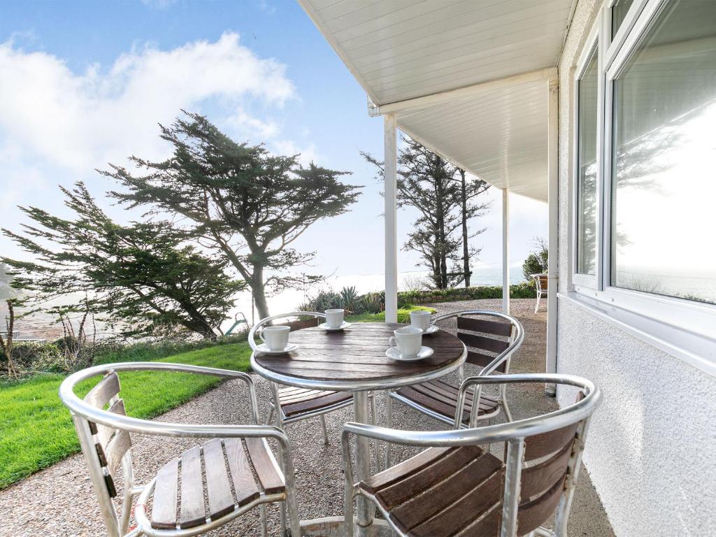 a table and chairs on the porch of a house at 6 Mount Brioni in Downderry