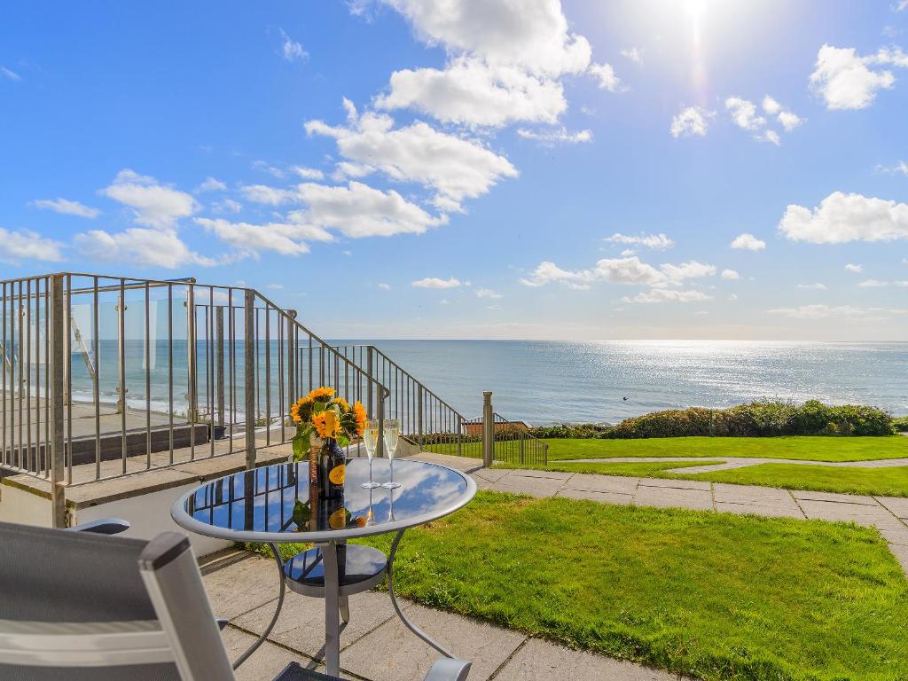 a patio with a table and a view of the ocean at 21 Mount Brioni in Downderry