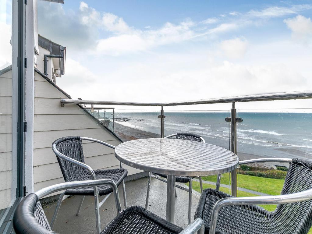 a patio with a table and chairs and the ocean at 18 Mount Brioni in Downderry